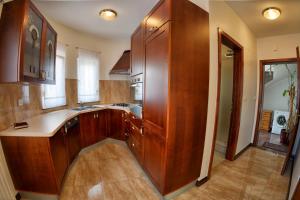 una cucina con mobili in legno e un lavello di Apartments Sablic a Pola (Pula) Altre 12 foto