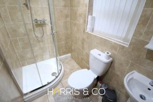 a bathroom with a shower and a toilet and a sink at Fishermans Rest in Fleetwood