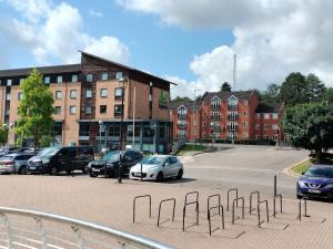 a parking lot with cars parked in front of a building at Canalside Chic Your London Escape Starts Here WIFI and Airport Transfers in Hemel Hempstead