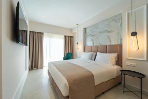 a bedroom with a large bed and a large window at Philia Center Suites in Rhodes Town
