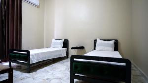 two beds in a room with green and white at Dortoir 25 Constantine in Constantine
