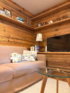 Una sala de estar con un sofá y una mesa de cristal. en L'Atelier du Temps - Maison du Glacier, en Entrèves