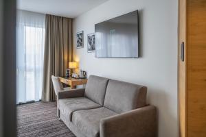 a living room with a couch and a table at Brit Hotel Strasbourg Le Lodge in Strasbourg