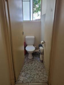 a small bathroom with a toilet and a window at Private Room close to beach & tram in Gold Coast