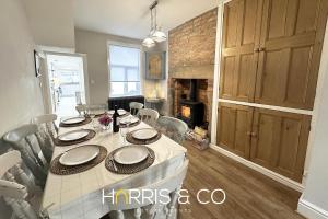 a dining room with a table and a fireplace at Admirals Rest in Fleetwood