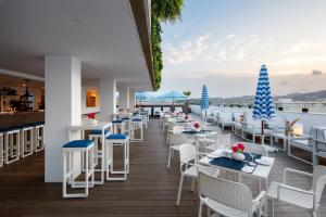 イビサ・タウンにあるEurostars Puerto de Ibizaの水辺の景色を望むレストラン(白いテーブルと椅子付)