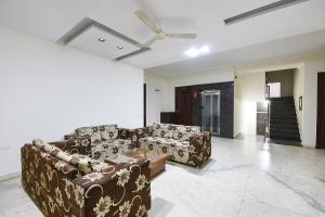 a living room with two couches and a ceiling fan at Gazelle Inn in Gurgaon