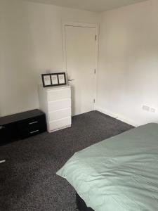 a bedroom with a bed and a dresser and a closet at ComfortVilla in Hornchurch