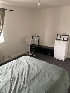 a bedroom with a bed and a desk and a tv at ComfortVilla in Hornchurch