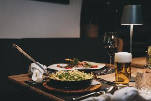 a table with a bowl of salad and a glass of beer at Der Gollinger in Saalbach-Hinterglemm