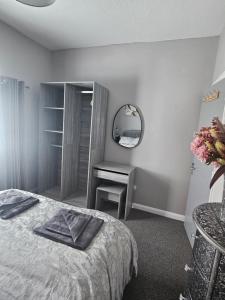 a bedroom with a bed and a table and a mirror at Apartment Mary Street in Porthcawl