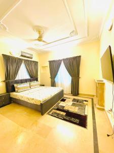 a bedroom with a bed and a tv in it at Ayyan Cottage G 10-2 in Islamabad