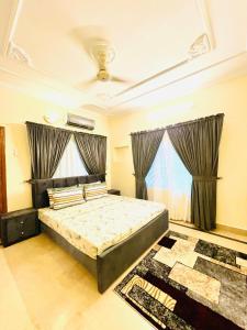 a bedroom with a bed and two windows at Ayyan Cottage G 10-2 in Islamabad