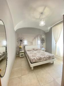 a bedroom with a white bed and a mirror at ABETI'S HOUSE in Rome
