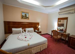 a hotel room with a large bed and a desk at Taj Celine Hotel in Jeddah +33 photos