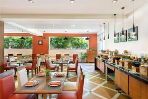 a dining room with tables and chairs in a restaurant at The Avenue Center Hotel in Cochin