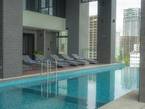 a swimming pool with lounge chairs in a building at Grand La Vogue Hotel and Casino in Sihanoukville