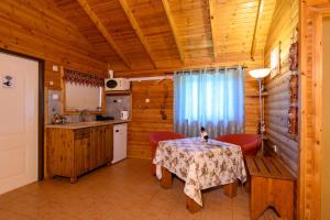 a kitchen with a table and chairs in a cabin at אביב בכרם - בקתות כפריות מקסימות עם ג'קוזי מול נוף מדהים in Ramot Naftali