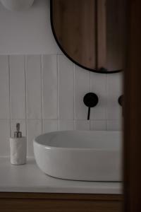 a white sink in a bathroom with a mirror at Leśne Chatki - Apartamenty Świerk i Sosna in Koniaków