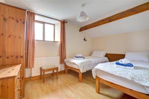 une chambre avec deux lits et une fenêtre dans l'établissement Wagtail Cottage, à Tosside 18 autres photos