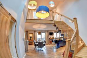 a living room and dining room with a spiral staircase at Feathered Nest in Hornby