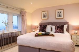 a bedroom with a large bed with a tray on it at Feathered Nest in Hornby