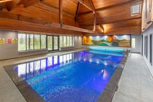 une piscine dans une maison avec un plafond en bois dans l'établissement Wagtail Cottage, à Tosside