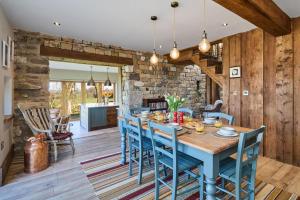 a dining room with a blue table and chairs at Hardwick House Barn in Addingham