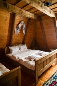 a bedroom with a bed in a wooden house at Poiana Creasta Cocoșului-Casa Floare De Nu Mă Uita in Breb