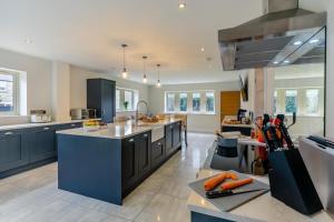 a large kitchen with blue cabinets and a large island at Spring Bank View - Holmfirth in Holmfirth
