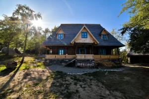 a house with a gambrel roof on a yard at Poiana Creasta Cocoșului-Casa Floare De Nu Mă Uita in Breb