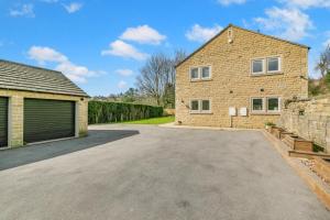a house with a garage and a driveway at Spring Bank View - Holmfirth in Holmfirth