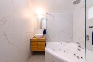 a bathroom with a tub and a sink at אביב בכרם - בקתות כפריות מקסימות עם ג'קוזי מול נוף מדהים in Ramot Naftali +20 photos