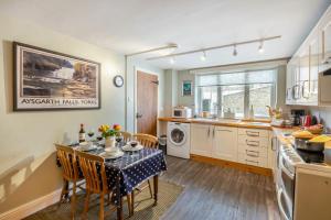 a kitchen with a table and chairs in a kitchen at Butlers Cottage in Hardraw