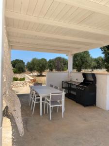 a outdoor kitchen with a table and a grill at white moon holiday home in Ostuni