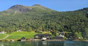 una casa a orillas de un lago frente a una montaña en Lakeside apartment, en Stryn