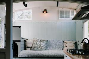 a couch in a small kitchen with a stove at Little Vineyard Caboose in Drummond