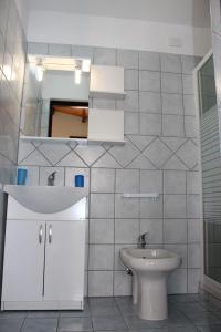 a white bathroom with a sink and a toilet at Albatros in Capoterra