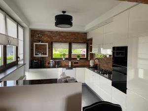 a kitchen with white appliances and a brick wall at REWA pokoje gościnne in Rewa