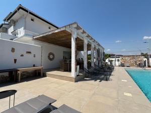 a patio with chairs and a swimming pool at Vila Alaris Vama Veche in Vama Veche