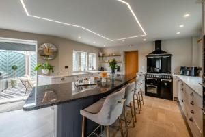 a kitchen with a large island with bar stools at Johns Cottage in Hampsthwaite