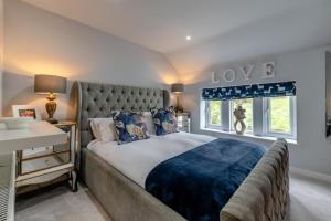 a bedroom with a large bed with a blue blanket at Johns Cottage in Hampsthwaite +27 photos