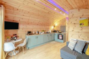 a log cabin with a kitchen and a living room at Woody in East Cowton
