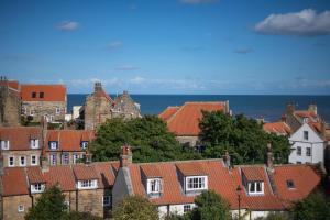a view of a town with houses and the ocean at Hillside in Robin Hood's Bay