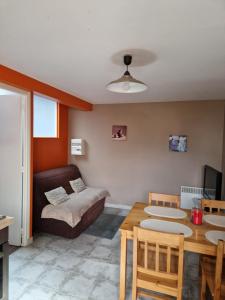a living room with a bed and a table and a dining room at gites de l'archange in Courtils