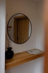 a round mirror on a shelf in a room at Leśne Chatki - Apartamenty Świerk i Sosna in Koniaków