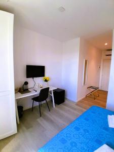 a room with a desk with a computer and a television at Virgy White rooms in Bari