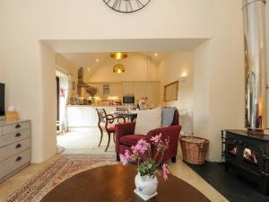 a living room with a fireplace and a table with flowers at Lydgate Cottage, Dartmoor in Postbridge +9 photos