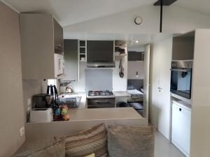 a kitchen with white cabinets and a couch in a room at Domaine De Dugny in Veuzain-sur-Loire
