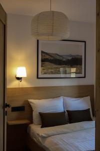 a bedroom with a bed with a lamp and a picture at Leśne Chatki - Apartamenty Świerk i Sosna in Koniaków